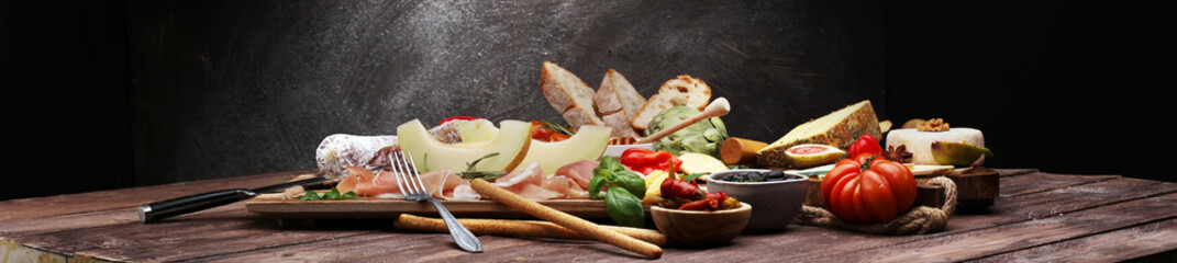 Italian antipasti wine snacks set. Cheese variety, Mediterranean olives, pickles, Prosciutto di...