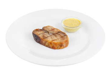 Steak of dark beef, pork, lamb, grilled meat, barbecue, on a plate isolated white background. Mustard, yellow sauce. Juicy fillet, medium, strong roast. For the menu in the restaurant, bar. Side view