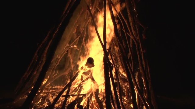 night fire sparks flying in the dark night sky, big night bonfire in a clearing in the forest