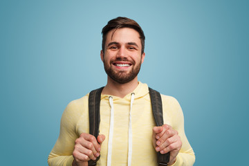 Excited laughing male student on blue - obrazy, fototapety, plakaty
