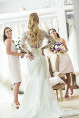Fototapeta na wymiar Happy women in wedding dresses in wedding fashion shop
