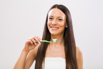 Portrait of  beautiful brunette woman  holding toothbrush.