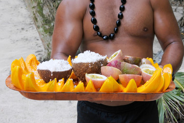 Cook Islander man serves coconut and papaya fruit on a tray in Rarotonga, Cook Island
