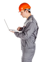 male builder in a helmet with notebook  over white wall background. repair, construction, building, people and maintenance concept.