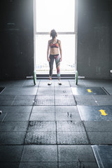 Determined sportswoman lifting heavy barbell