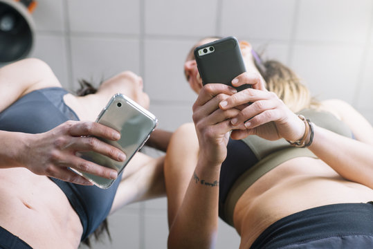 two woman with phone in gym