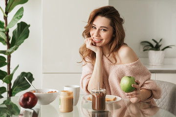 Portrait of a lovely young woman having tasty breakfast