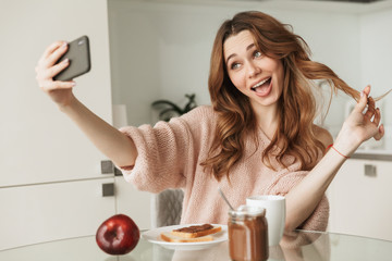 Portrait of a pretty young woman taking a selfie