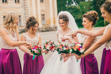 Bride With Bridesmaids On Wedding Day. Bride show bridesmaids her new ring. The girls laugh. Funny wedding moments.