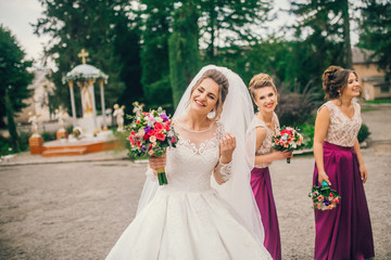 Stylish bridesmaids have fun with bride. Trendy wedding, same bridesmaids dresses