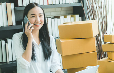 young asian businesswoman sitting happy to mobile phone online shopping working with box package, clear tone process style
