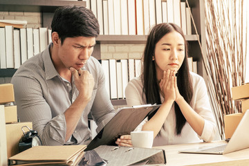 Asian couple manager sitting unhappy and stress in problem sme working at home office with box package, warm process style