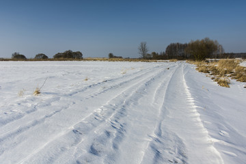 Fototapeta na wymiar Dirt road covered with snow