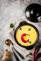 Traditional Indian cuisine. Vegetarian curry Gujarati Kadhi, Gujarati daal soup, with spices on grey stone background copy space top view