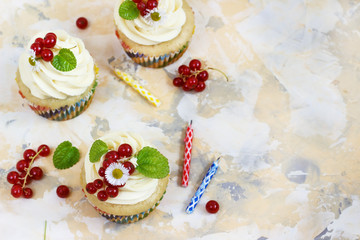 Gentle cupcake with cream and berries nd a candle a light background