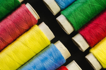Spools of colored sewing thread closeup