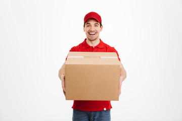 Excited happy young delivery man in red cap - obrazy, fototapety, plakaty