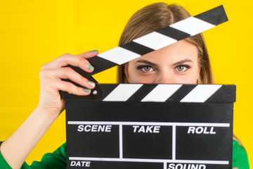 Attractive woman with a clapperboard in her arms - obrazy, fototapety, plakaty