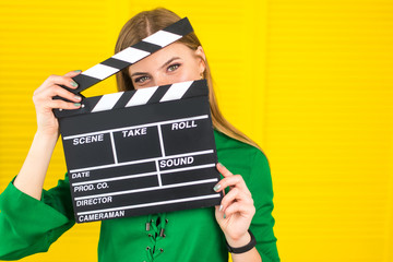 Attractive woman with a clapperboard in her arms