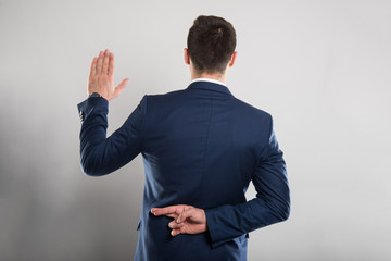 Back view of business man taking fake oath gesture