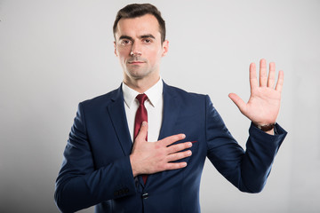 Attractive business man taking oath gesture