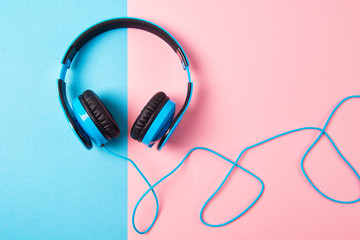 Headphones on blue and pink background, top view