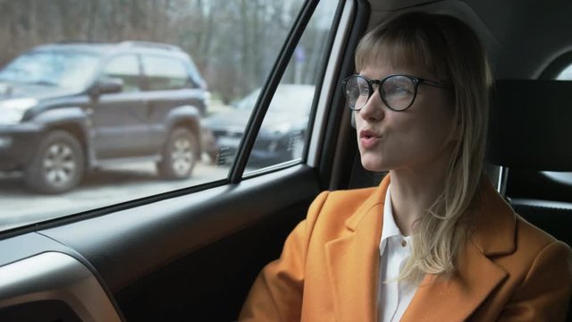 Nervous Businesswoman Talking to the Not Visible Driver