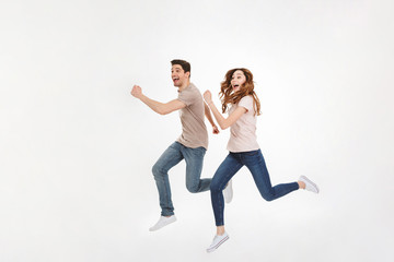 Fototapeta na wymiar Full-length photo of energetic couple man and woman in casual t-shirt running and smiling on camera with happy look, isolated over white background