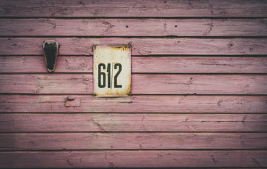 Number plate of street address on a wooden house in Bauska, Latvia. Vintage sign on a wooden building.
