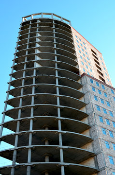 unfinished construction of a high-rise building of concrete against the blue sky