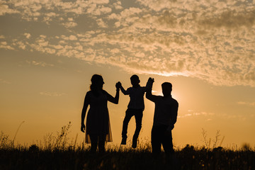 Family on sunset background