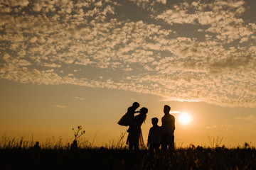 Obraz na płótnie Canvas Silhouette of a family against the sky