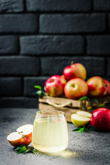 Apple ginger kombucha cocktail and fresh apples in wooden box on concrete background. Selective focus, space for text.