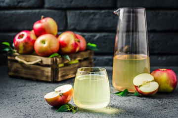 Apple cider vinegar drink and fresh apples in wooden box on concrete background. Selective focus, space for text.
