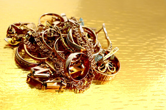 gold jewelry, folded pile on a gold background and brightly lit