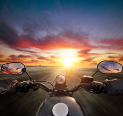 Naklejka premium POV kierowcy motocykla trzymającego kierownicę, kierującego się na nowoczesną panoramę miasta.