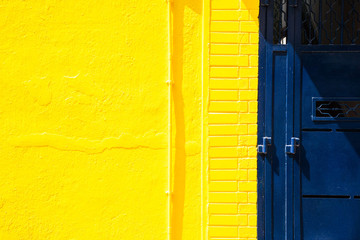 Yellow wall and blue metal door background