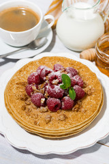 traditional pancakes with fresh raspberries for breakfast on wooden table, vertical top view