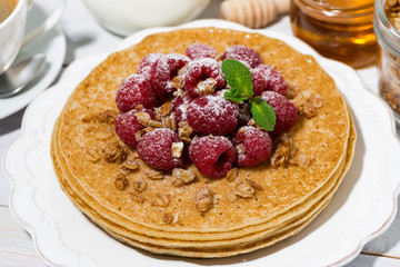 traditional pancakes with fresh raspberries for breakfast on wooden table, top view closeup