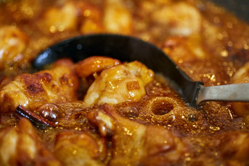 Chicken wings in a wok, boiling