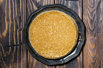 traditional thin pancakes on a plate, top view