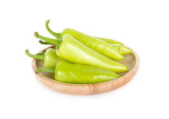 fresh green chili peppers with stem in wooden plate on white background