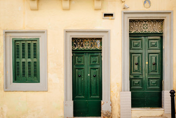 Facade of traditional maltese house in Valletta with beautiful green doors, Malta