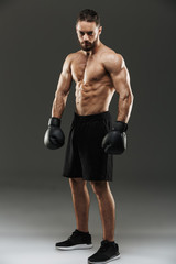 Fototapeta na wymiar Full length portrait of a confident shirtless muscular sportsman