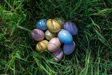 Colorful Easter eggs on the grass in sunny day. Easter concept.
