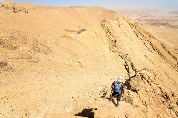 Fototapeta na wymiar Backpacker tourist standing desert mountain cliff ridge edge landscape.