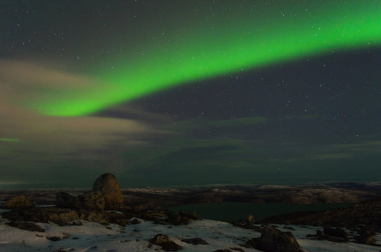 Northern Lights, polar lights above the hills and tundra bay in winter.