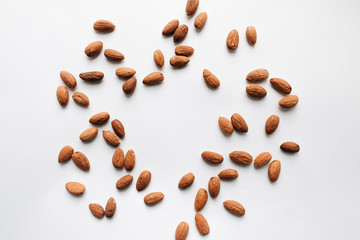 Pile of almonds on white background with copy space, healthy eating concept
