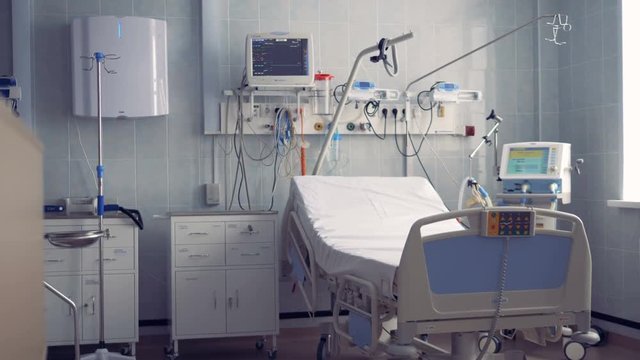 A hospital ward for one person with a bed and equipment