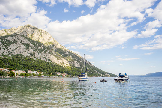 View on boats, beach and mountains behind in Gradac, Croatia. Popular tourist destination.